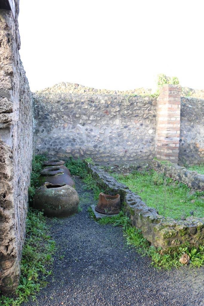 I.21.2 Pompeii. December 2018. 
Looking towards west wall, dolia and puteal. Photo courtesy of Aude Durand.