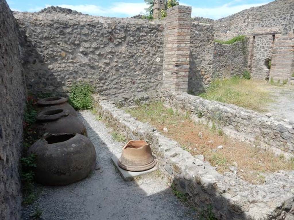 I.21.2 Pompeii. May 2017. Looking towards west wall, dolia and puteal.  Photo courtesy of Buzz Ferebee.