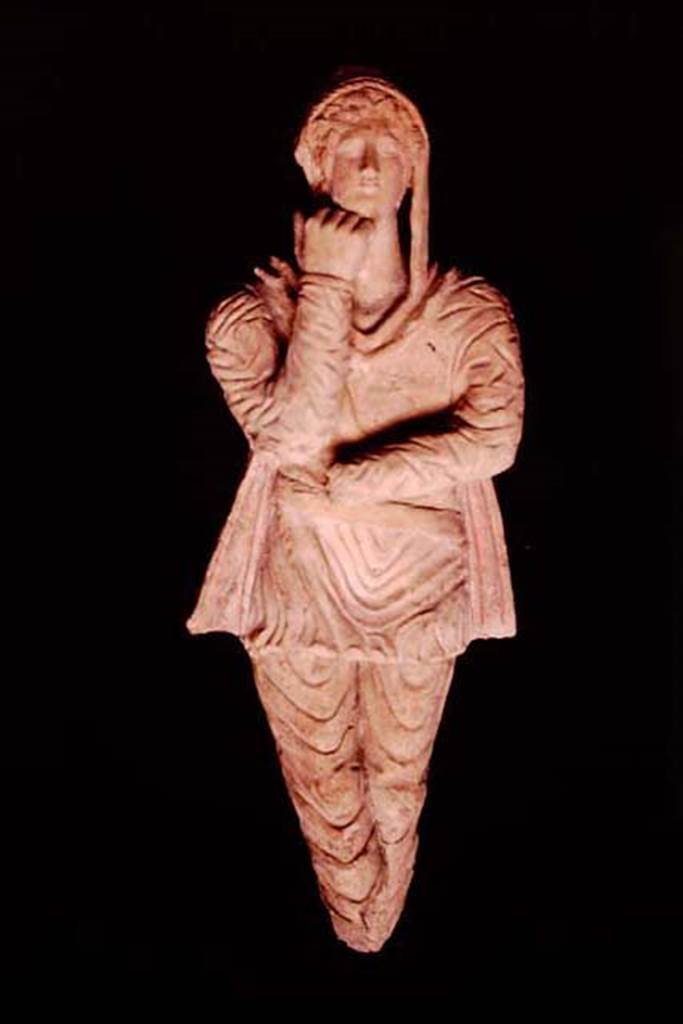 Pompeii, 1982 or 1983. Terracotta statuette of Attis discovered in the area “next to the wall of the ancient well”.   
This second statuette has the arms and legs positioned inverted and the hand that supports the chin is more closed compared to 10309. 
SAP inventory number 10310.
Source: The Wilhelmina and Stanley A. Jashemski archive in the University of Maryland Library, Special Collections (See collection page) and made available under the Creative Commons Attribution-Non Commercial License v.4. See Licence and use details.
J80f0500
See D’Ambrosio A. and Borriello M., 1990. Le terrecotte figurate di Pompei: SAP cat. 4. Roma: L’Erma di Bretschneider, p. 24, n. 17, Tav. V.
