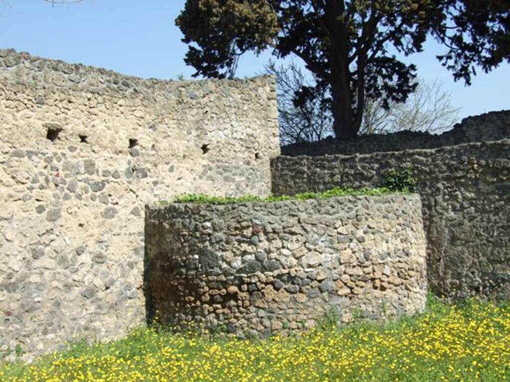 II.1.11 Pompeii. March 2009. Semi circular high masonry walled area with no entrance, forming a small arc-shaped area in north-east corner of garden area. This was possibly to be used for water storage. According to Jashemski, Dr. DeCaro had suggested to her that this might have been an above ground cistern in the process of construction.  See Jashemski, W. F., 1993. The Gardens of Pompeii, Volume II: Appendices. New York: Caratzas. (p.76)