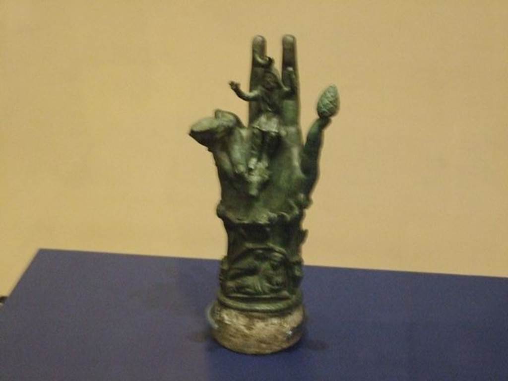 II.1.12 Pompeii. Bronze hand of Sabazius. SAP 10486. 
Photographed at “A Day in Pompeii” exhibition at Melbourne Museum. September 2009.  According to Berry, SAP 10486 was one of two similar votive hands found in a shrine at the house at II.1.12. Sabazius was sitting in the centre of the palm with his arms raised in benediction. Around the hand are a snake, a caduceus, a knife, a scale and a woman with child.According to Berry, Sabazius was often equated with Zeus or Dionysus. See Berry, J., 2007. The Complete Pompeii. London, Thames & Hudson, (p.200-1). See Conticello, B., Ed, 1990. Rediscovering Pompeii. Rome: L’Erma di Bretschneider. (p.138-139). Both hands, inventory numbers SAP 10485 and 10486 can be seen in Cibi e Sapori a Pompei e Dintorni, (p.37). See Cicirelli, C. (2005): Religio: feste e rituali del culto pubblico e privato, (p.20-38) in the above book.