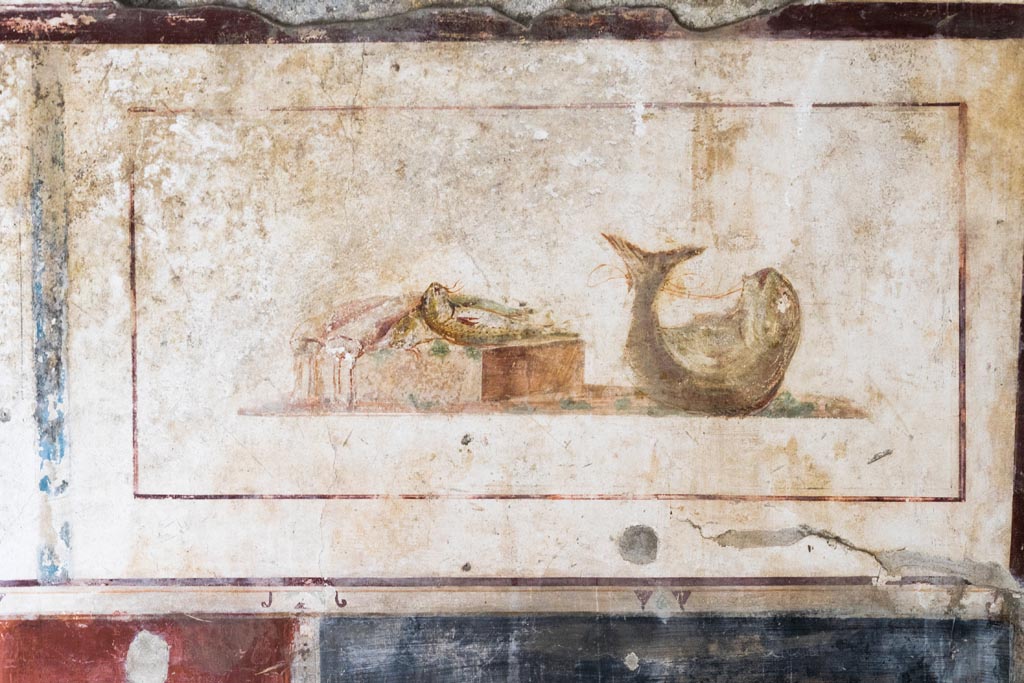 II.1.12 Pompeii. July 2021. 
Triclinium, upper panel on west wall at north end, with wall painting of fishes. Photo courtesy of Johannes Eber.