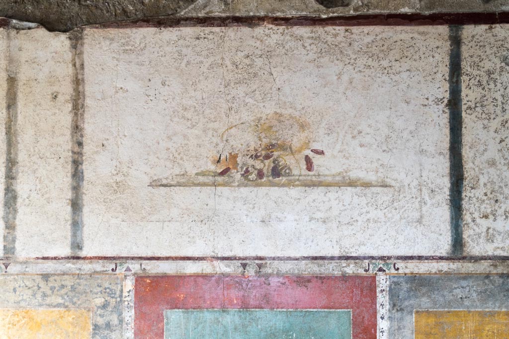 II.1.12 Pompeii. July 2021. 
Triclinium, upper panel from centre of south wall with painting of a fallen basket and dates. Photo courtesy of Johannes Eber.