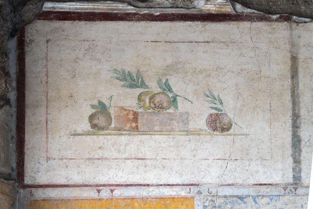 II.1.12 Pompeii. July 2021. 
Triclinium, upper painted panel from south wall at east end with painting of pomegranates. Photo courtesy of Johannes Eber.