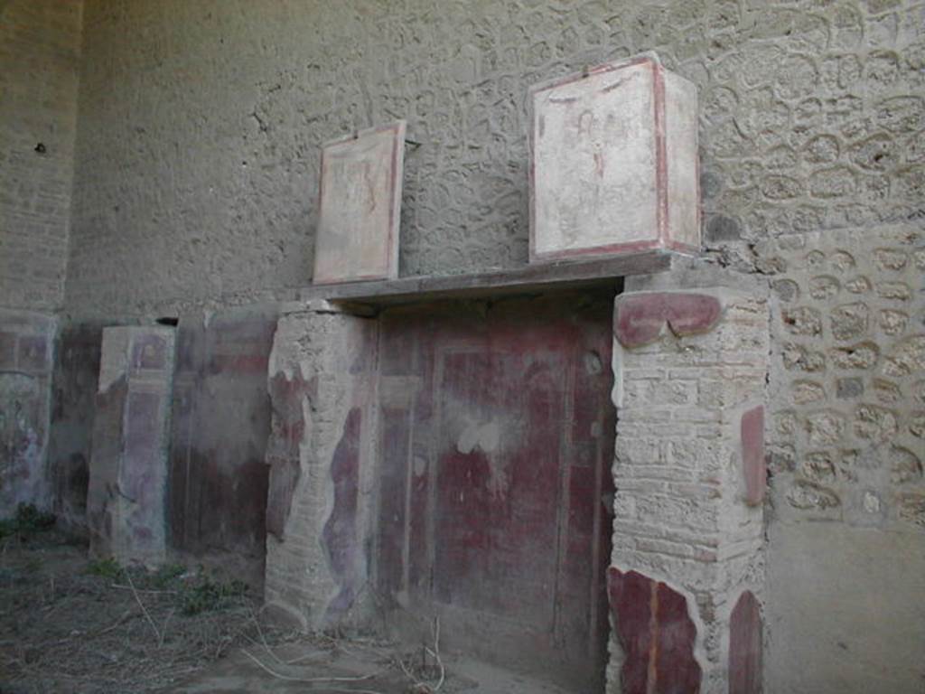 Pompeii. May 2005. Two pilaster paintings (at top on beam) from entrance façade of II.1.12 Complesso dei Riti magici.
These were in III.3.6 and are reversed.
See Fröhlich, T., 1991, Lararien und Fassadenbilder in den Vesuvstädten. Mainz: von Zabern. (F16:p.312, T. 54/1 and 54/2).
Following the collapse in November 2010, these are believed to have been destroyed.
