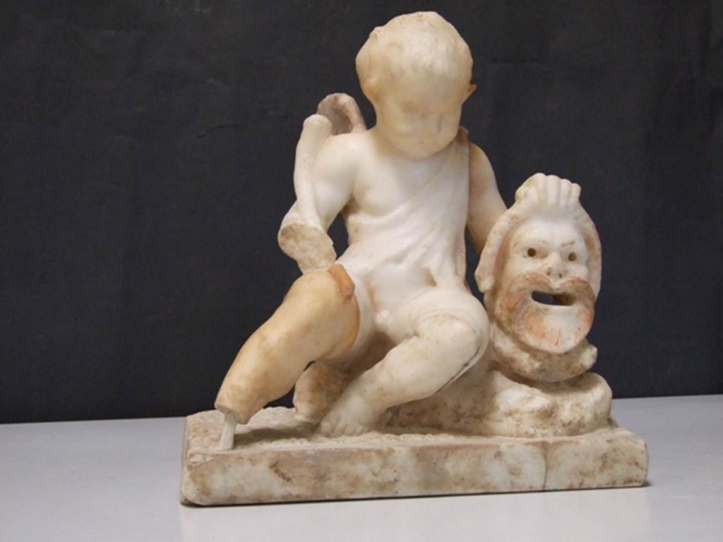 II.2.2 Pompeii. March 2009. Room “l”, garden. White marble statuette of a cupid with a mask. 
Found above the marble steps in the nymphaeum at the top of the lower euripus in the garden in 1920. 
SAP inventory number: 20513.