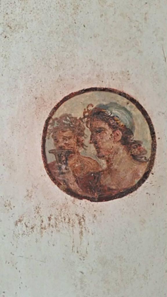 II.2.2 Pompeii. 2016/2017.
Room “f”, round painted portrait medallion of two faces, from the east wall. 
Photo courtesy of Giuseppe Ciaramella.