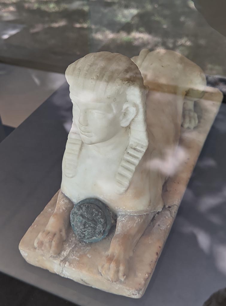 II.2.2 Pompeii. April 2022. 
Room “i”, white statuette of Sphinx, found on the north side of the upper euripus, here on display in exhibition in Palaestra.
Photo courtesy of Giuseppe Ciaramella.