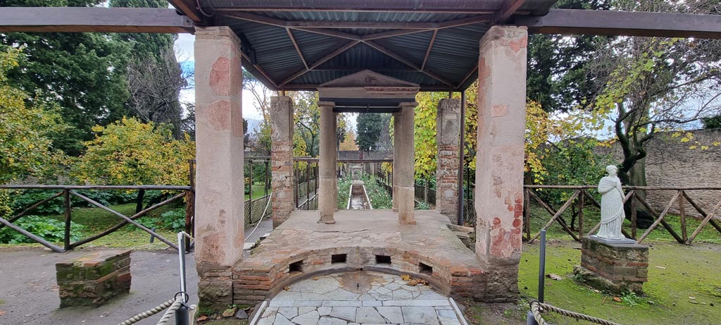 II.2.2 Pompeii. December 2023.
Room “i”, looking south to temple at junction of upper and lower euripus, see room “l” (L) for further photos of the lower garden area.
Photo courtesy of Miriam Colomer.
