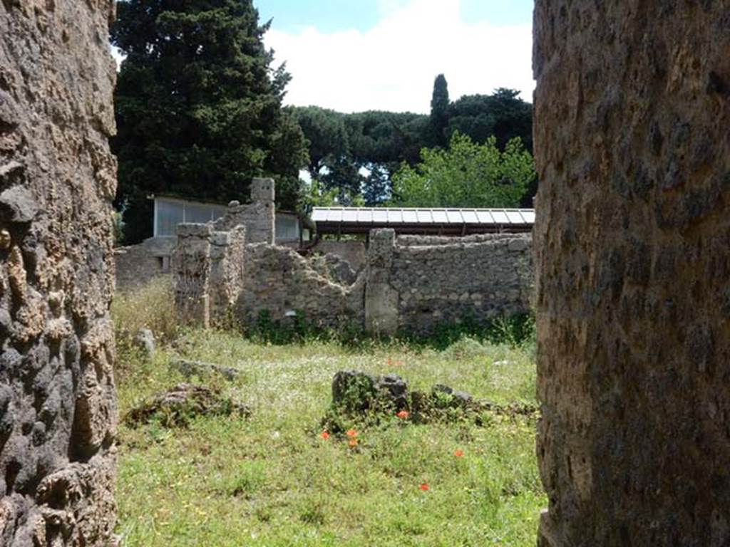 II.2.4 Pompeii. May 2016. Looking south from entrance corridor 1 and 2 to north portico and peristyle garden 4.
The roofing at the bottom is the upper euripus and biclinium of II.2.2 which shares a common wall with the narrow rear garden 10 of II.2.4.
Photo courtesy of Buzz Ferebee.