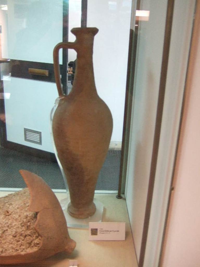 Flagon for Garum found at II.3.1. Now in Boscoreale Museum.
According to Stefani, at the moment of excavation, the letters MC painted in black were visible near the neck of the amphora.
The writing is no longer visible.
See Cibi e Sapori a Pompei e Dintorni, SAP, 2005 (p.88, no.100)