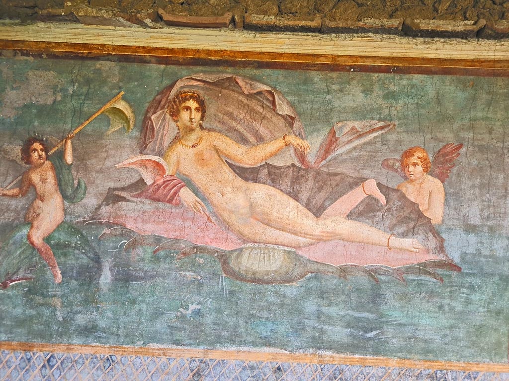 II.3.3 Pompeii. March 2024. 
Room 11, central panel from south wall with Venus/Aphrodite in a shell. One cupid rides on a dolphin, the other is supporting the shell.  
Photo courtesy of Giuseppe Ciaramella.