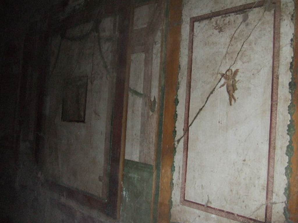 II.3.3 Pompeii. December 2005. Room 4, south wall of cubiculum. 
A flying cherub is on the near panel. The remains of a wall painting of Hermes and Dionysus is in the central wall panel.