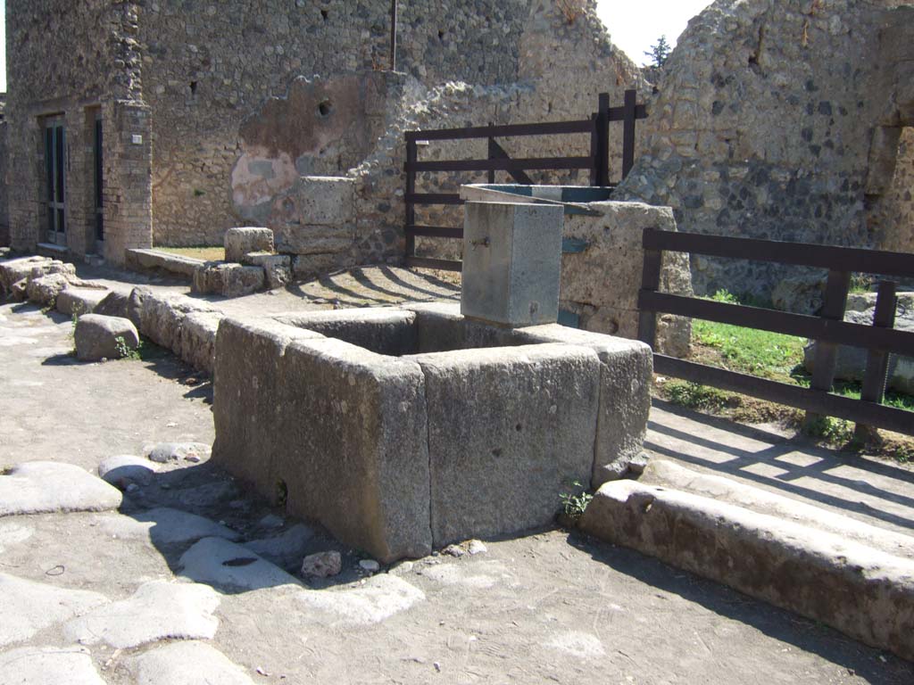 Fountain outside II.3.5. September 2005. Looking south-east towards fountain with replacement pilaster.
According to Parslow –
the fountain pilaster or “lava standard” was described by Weber as being decorated with a mask wreathed with clusters of grapes.
The original was removed and transported to the royal villa at Portici.
See Parslow, C.C. (1998). Rediscovering Antiquity: Karl Weber and the Excavation of Herculaneum, Pompeii and Stabiae. UK: Cambridge UP (pp.121,168 and 283)