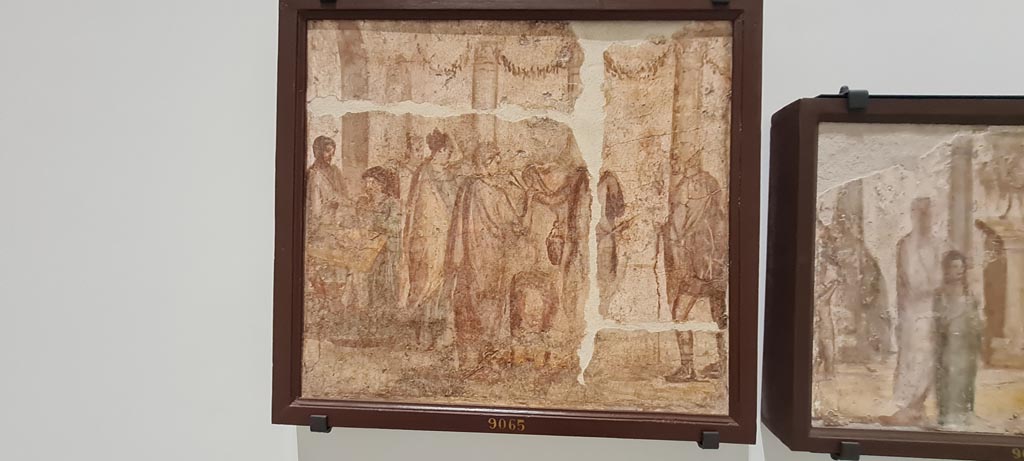 II.4.3 Pompeii. April 2023. Paintings of the Forum frieze, on display in “Campania Romana” gallery in Naples Archaeological Museum.
In centre (inv. 9065) – Vendita di commestibili presso un arco. (Sale of foodstuffs near an arch). Photo courtesy of Giuseppe Ciaramella.