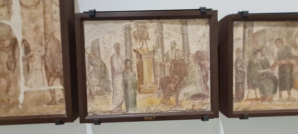 II.4.3 Pompeii. April 2023. Paintings of the Forum frieze, on display in “Campania Romana” gallery in Naples Archaeological Museum.
In centre (inv. 9067) – Vendita di un schiava. (Sale of a slave girl). Photo courtesy of Giuseppe Ciaramella.