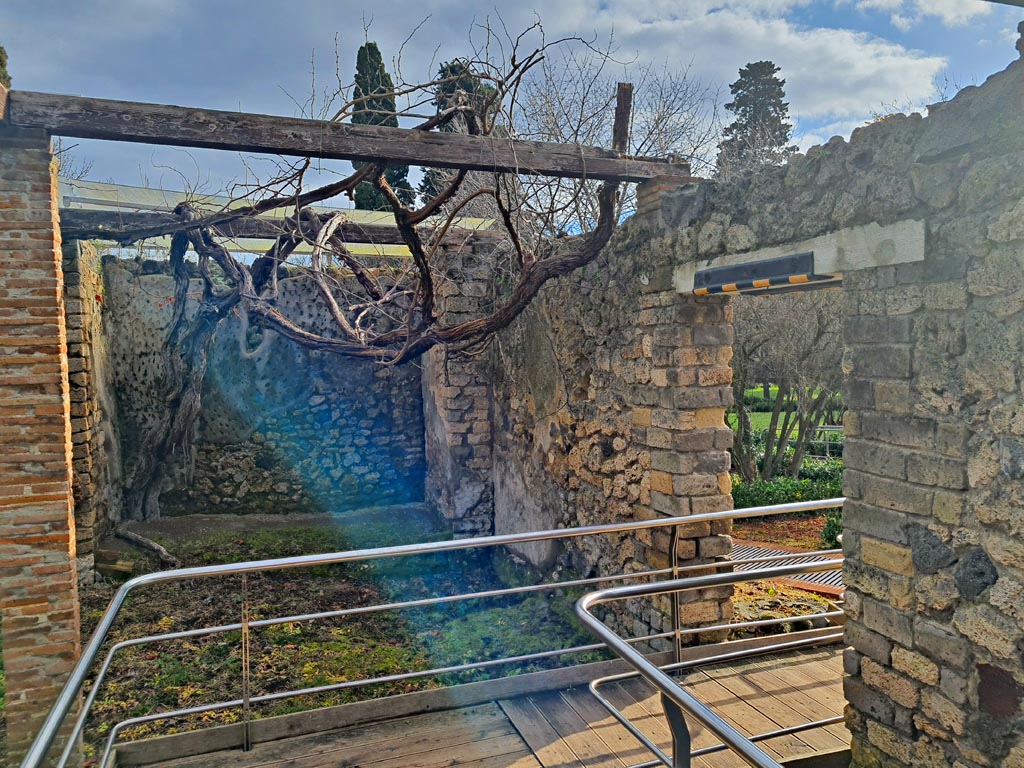II.4.6 Pompeii. March 2024. 
Looking east at south end of niches, with doorway into garden area, on right. Photo courtesy of Giuseppe Ciaramella.