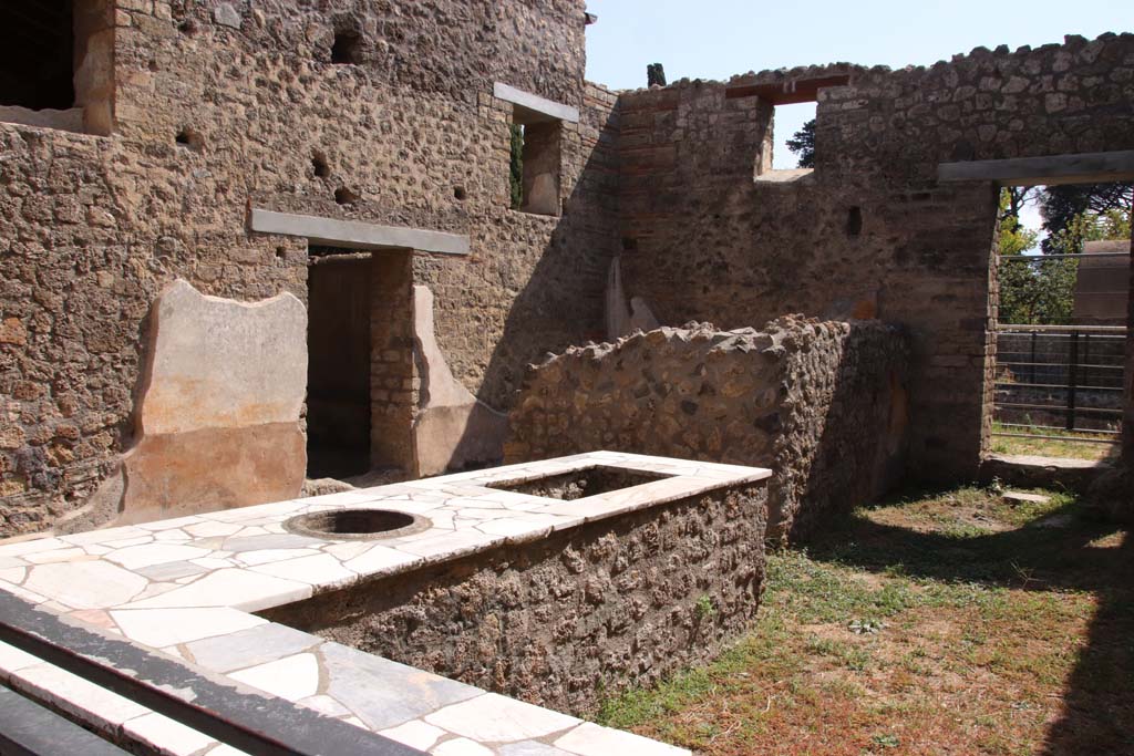 II.4.7 Pompeii. September 2019. Looking across podium towards east wall with doorway to triclinium, from entrance doorway.
Photo courtesy of Klaus Heese.