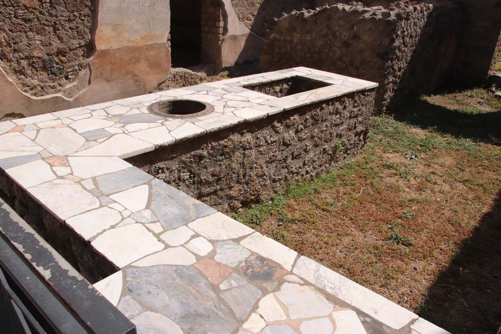 II.4.7 Pompeii. September 2019. Looking east across food counter/podium. 
Photo courtesy of Klaus Heese.