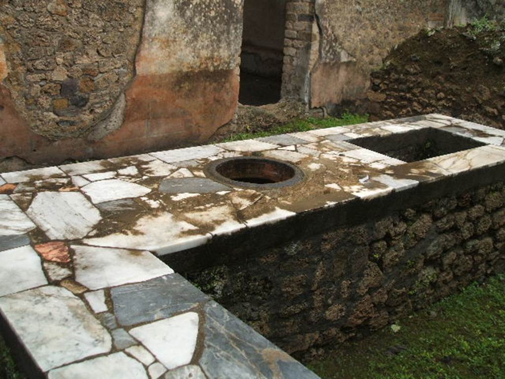II.4.7 Pompeii. December 2005. Food counter and door in east wall to triclinium.