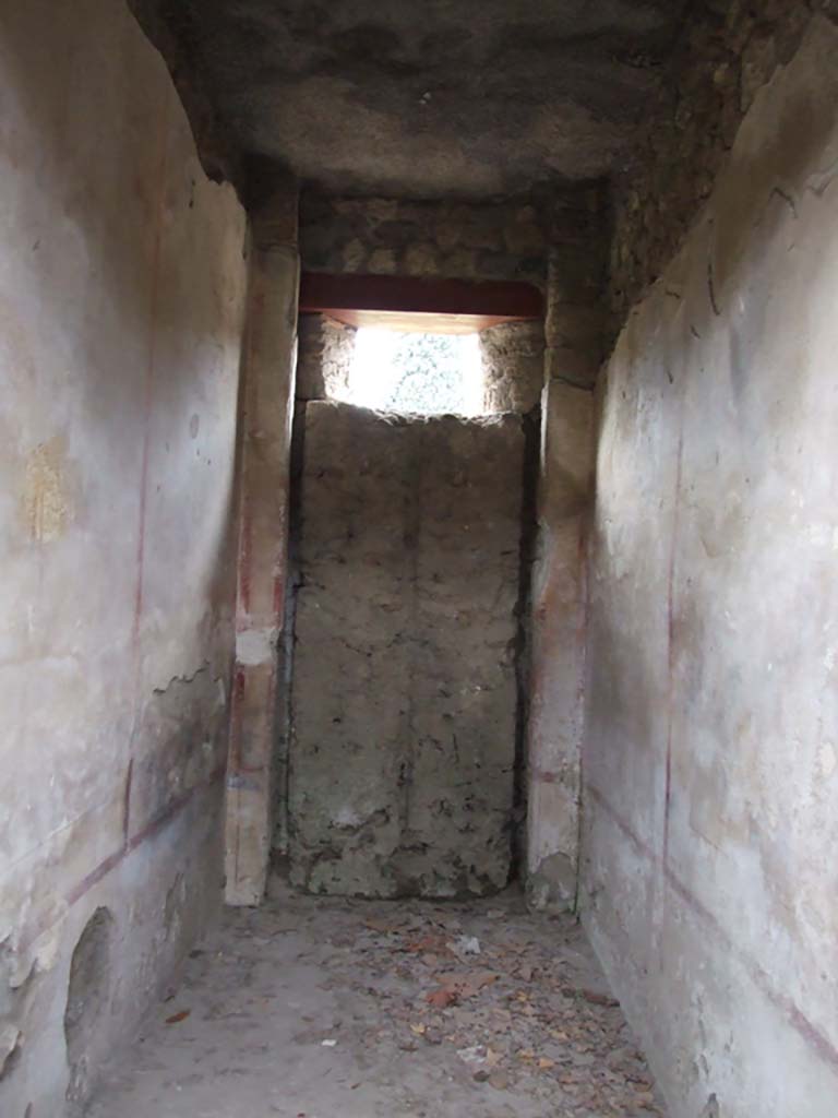 II.4.10 Pompeii. December 2006. Room with blocked door.
When the entrance onto the western roadway was walled up, the wooden door was left closed from the inside.
From this, it was possible to make a mould of the door, and from this it could be seen that it would have had double doors.