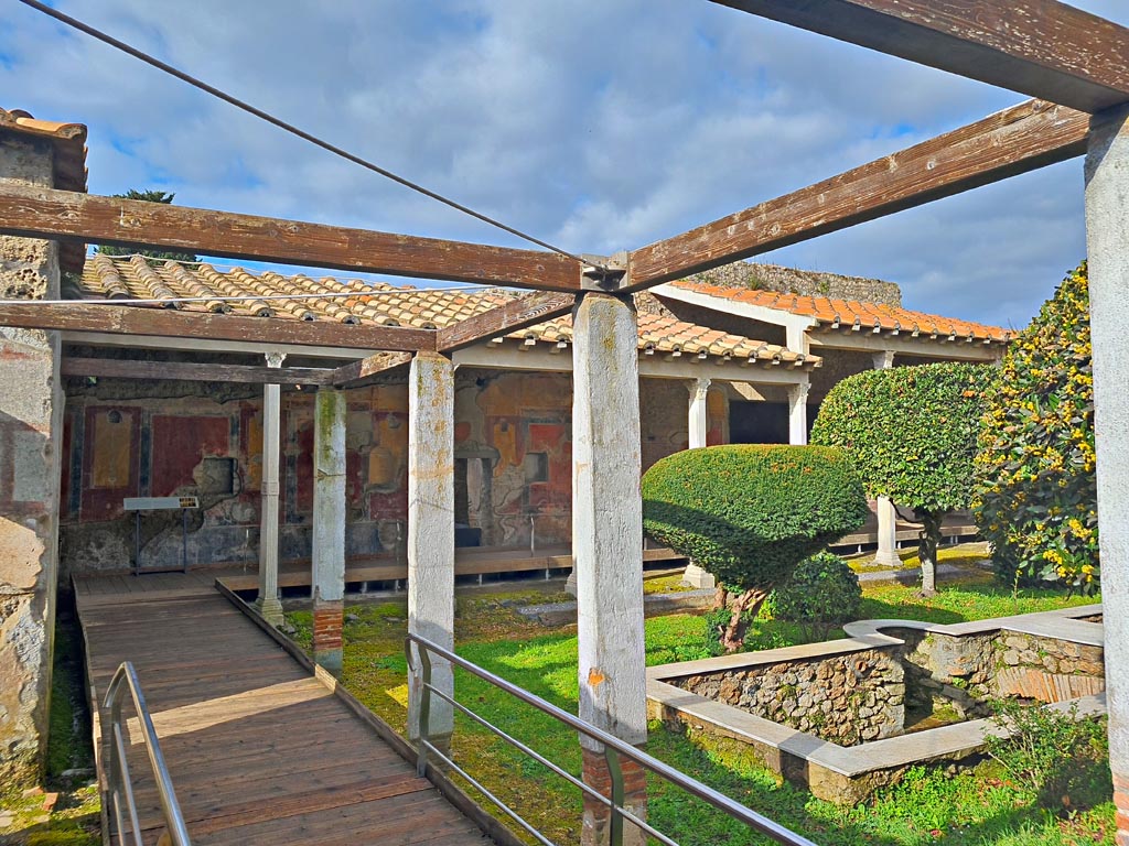 II.4.6/10 Pompeii. March 2024. 
Looking west along south portico of peristyle/garden, from doorway leading from rear garden at II.4.9. Photo courtesy of Giuseppe Ciaramella.
