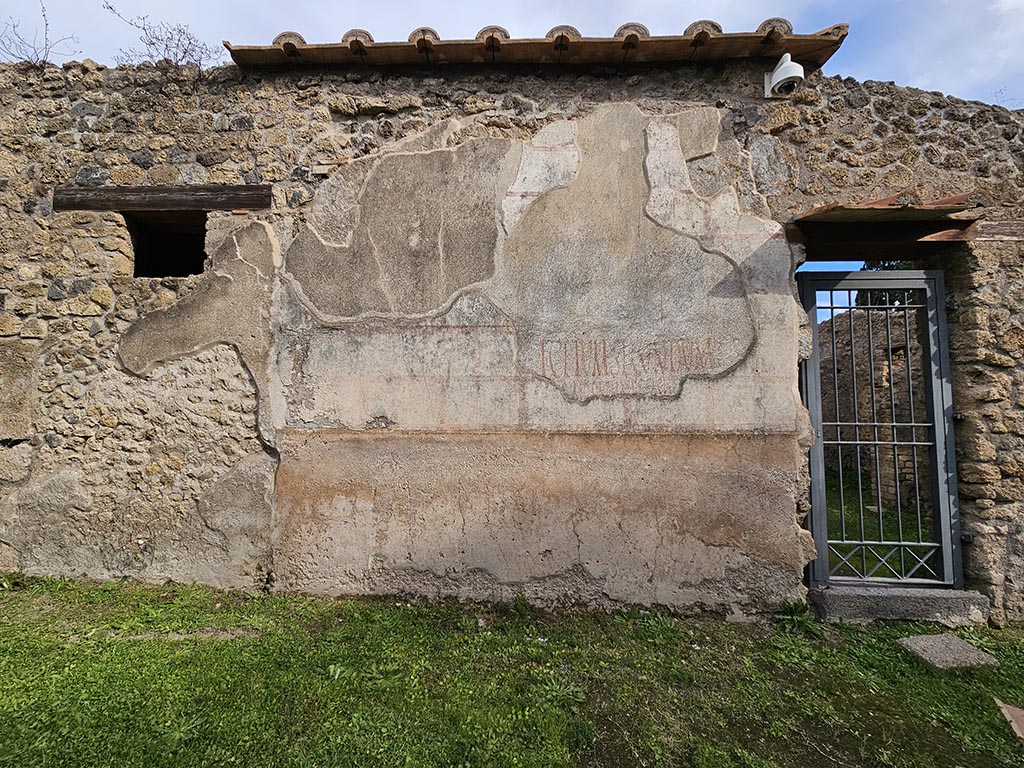II.4.10 Pompeii. November 2024. 
Exterior wall with painted inscriptions on north side of entrance doorway. Photo courtesy of Annette Haug.