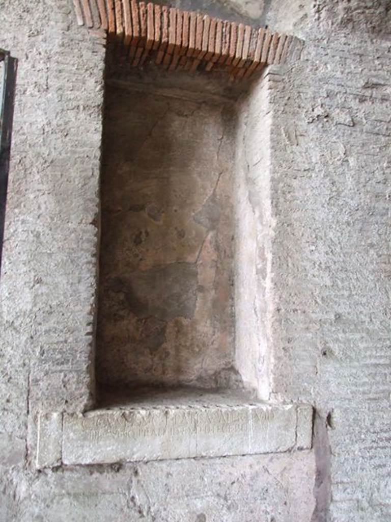 II.6 Pompeii. December 2006. Large rectangular niche, on east side of corridor of Amphitheatre, which had contained a statue of city magistrates. According to Mau, the niches in the north passage were adorned with two portrait statues of Gaius Cuspius Pansa, father and son. These were placed in the niches, in the east and west walls, facing each other. The statues have disappeared but the inscriptions are still readable. See Mau, A., 1907, translated by Kelsey, F. W., Pompeii: Its Life and Art. New York: Macmillan. (p. 219).