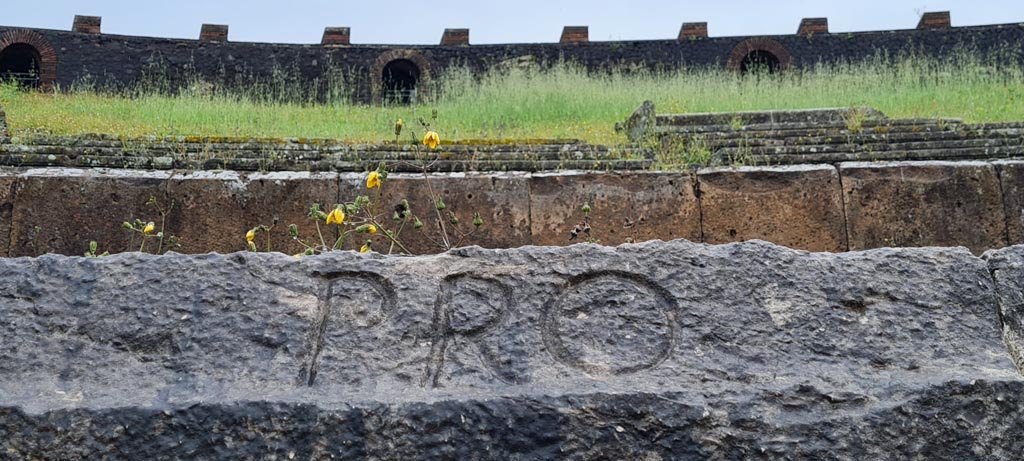 II.6 Pompeii. April 2022. Inscription carved on rim of inner wall of the arena of the amphitheatre -
Inscription PRO, part of CIL X 854.
Photo courtesy of Giuseppe Ciaramella.
