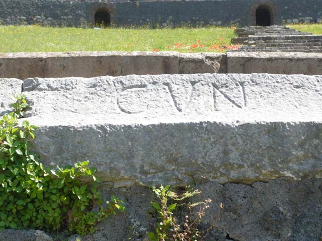 II.6 Pompeii. May 2012. Inscription CVN (cuneus) carved into rim of inner wall of the arena of the Amphitheatre.  
Photo courtesy of Buzz Ferebee 
According to Cooley, this relates to a particular section, or wedge, of seating (cuneus). 
See Cooley, A. and M.G.L., 2004. Pompeii: A Sourcebook. London: Routledge, p. 46.