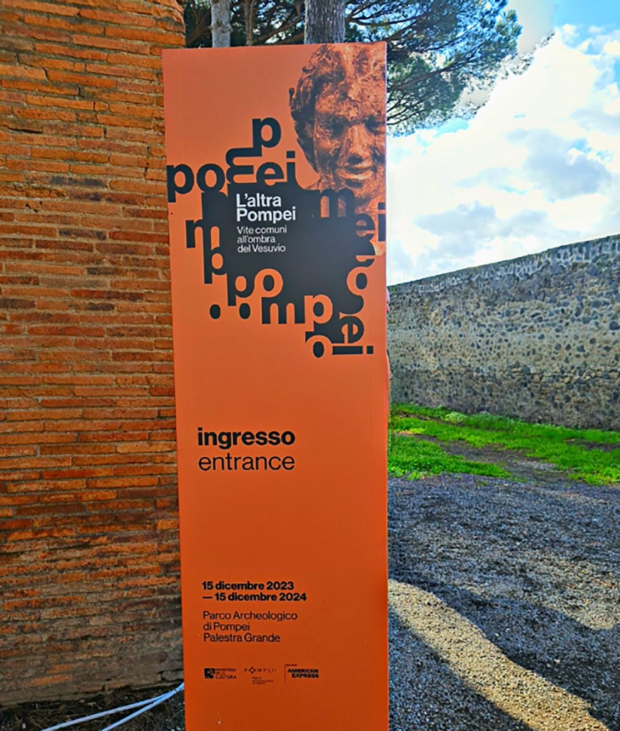II.7.8 Pompeii. March 2024. Advertisement for exhibition entitled - 
“L’altra Pompei, vite comuni all’ombra del Vesuvio” (“The other Pompeii, common lives in the shadow of Vesuvius.”)
From 15th December 2023 until 15th December 2024. Photo courtesy of Giuseppe Ciaramella.
