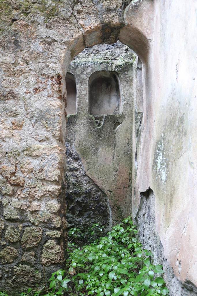 II.8.5 Pompeii. December 2018. 
Looking south through arched doorway into recess/niche containing three other niches. 
Photo courtesy of Aude Durand.