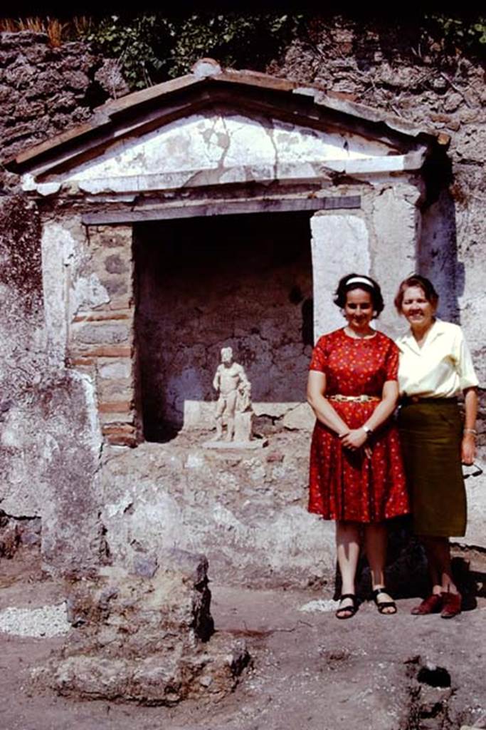 II.8.6 Pompeii, 1973. Wilhelmina and Prof. Giuseppina Cerulli Irelli standing near the lararium with Hercules. 
Photo by Stanley A. Jashemski. 
Source: The Wilhelmina and Stanley A. Jashemski archive in the University of Maryland Library, Special Collections (See collection page) and made available under the Creative Commons Attribution-Non Commercial License v.4. See Licence and use details.
J73f0614