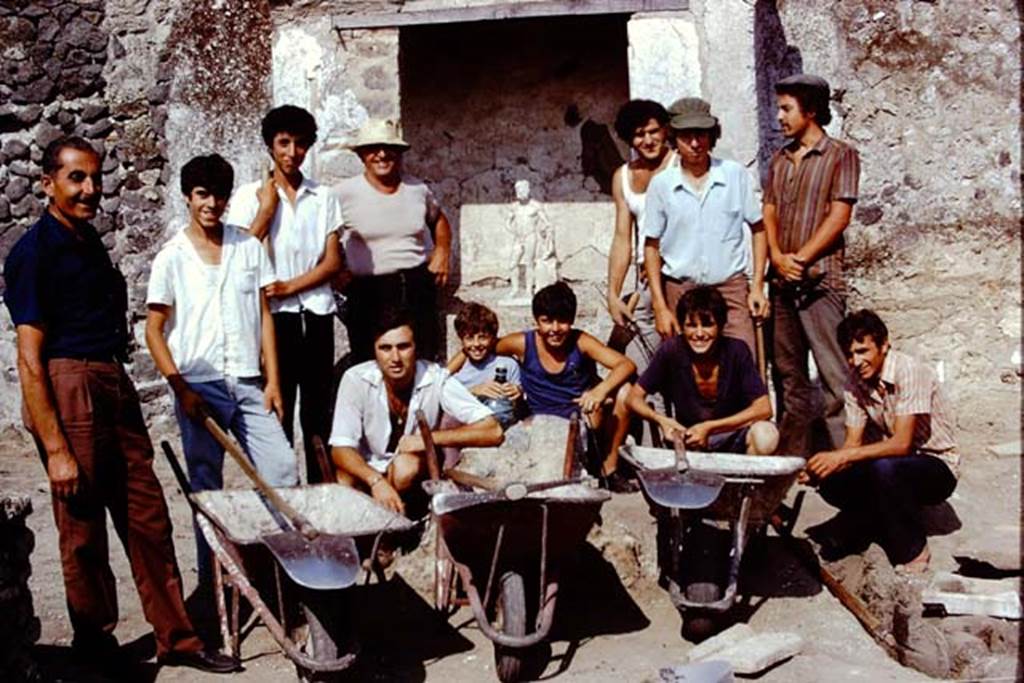 II.8.6 Pompeii, 1973. Wilhelmina’s workers having their photo taken near the lararium with the statue of Hercules. Photo by Stanley A. Jashemski. 
Source: The Wilhelmina and Stanley A. Jashemski archive in the University of Maryland Library, Special Collections (See collection page) and made available under the Creative Commons Attribution-Non Commercial License v.4. See Licence and use details. J73f0619