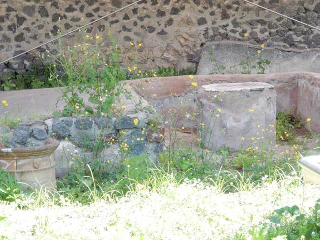 II.9.4, Pompeii. May 2018. Detail of triclinium, terracotta puteal, on left, and triclinium table.
Photo courtesy of Buzz Ferebee.