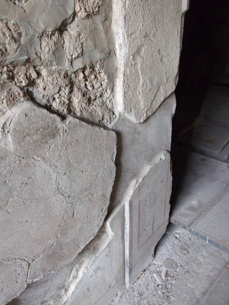 II.9.4 Pompeii. December 2007. Plaster on lower corner of north side of fauces wall.