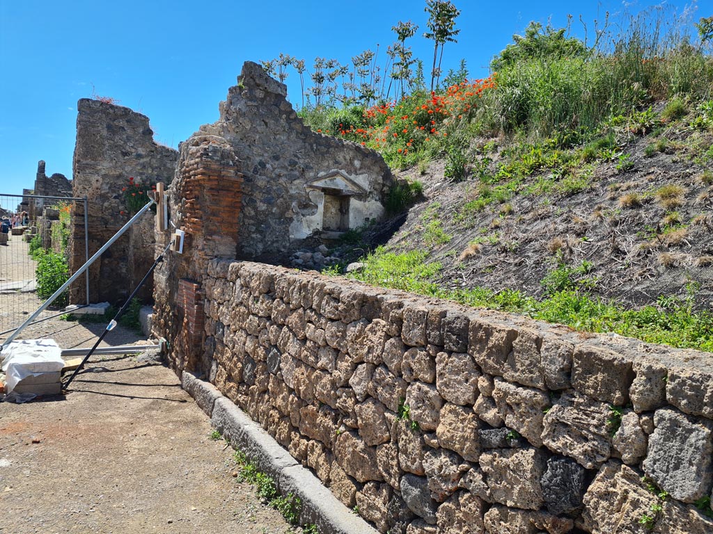 III.7.5 Pompeii. May 2024. 
Looking towards west side of entrance threshold, with niche in west wall of shop-room. Photo courtesy of Klaus Heese.