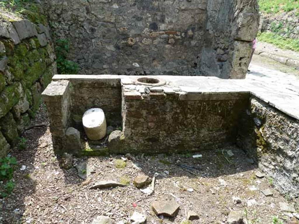 III.8.8 Pompeii. May 2010. Looking west from rear of two-sided bar counter. On 13th December 1902 at the edge of the podium or counter, a skeleton of a young boy was found. See Notizie degli Scavi di Antichità, 1905, (p.275).