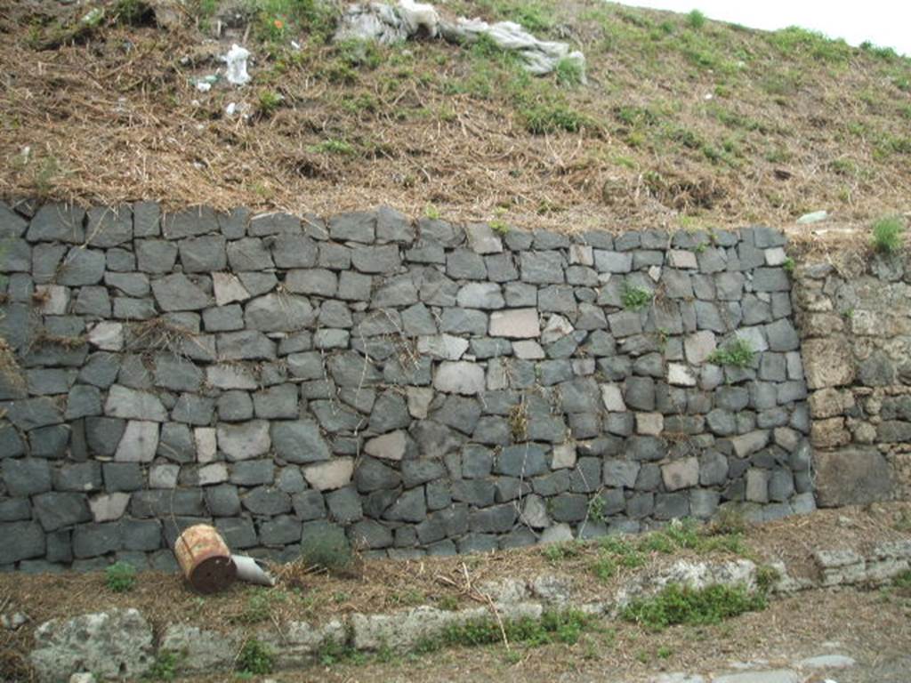 IV.1.b and IV.1.c Pompeii. May 2005. Site of entrances.
The doorways that used to front onto the northern side of Via Nola, forming Regio IV, have now been filled in as a wall to keep the earth bank back from the road.  It is very difficult to find the exact position of these doorways and link them to any site plan.