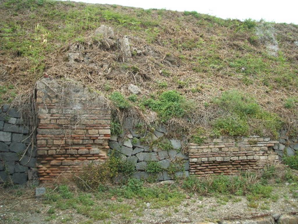 IV.1.f Pompeii. May 2005. Entrance, filled in with grey stones.
The doorways that used to front onto the northern side of Via Nola, forming Regio IV, have now been filled in as a wall to keep the earth bank back from the road.  It is very difficult to find the exact position of these doorways and link them to any site plan.