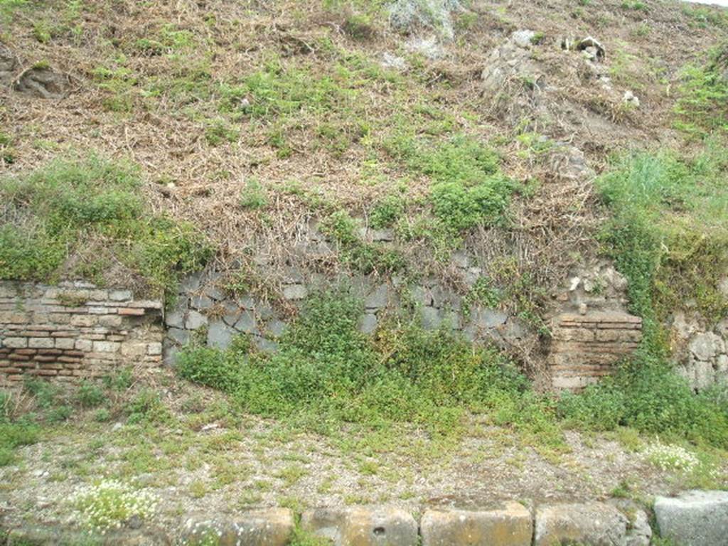 IV.1.g  Pompeii. May 2005.  Entrance.
The doorways that used to front onto the northern side of Via Nola, forming Regio IV, have now been filled in as a wall to keep the earth bank back from the road.  It is very difficult to find the exact position of these doorways and link them to any site plan.
