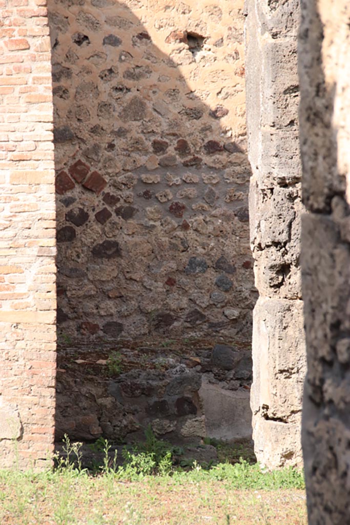 V.1.3 Pompeii. October 2023. 
Looking through doorway towards west side with remains of bench. Photo courtesy of Klaus Heese.