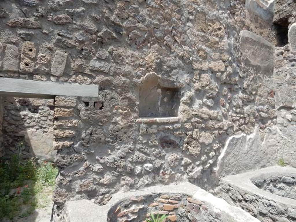 V.1.5 Pompeii. May 2017. North wall with doorway to rear room, niche and boilers.
Photo courtesy of Buzz Ferebee.