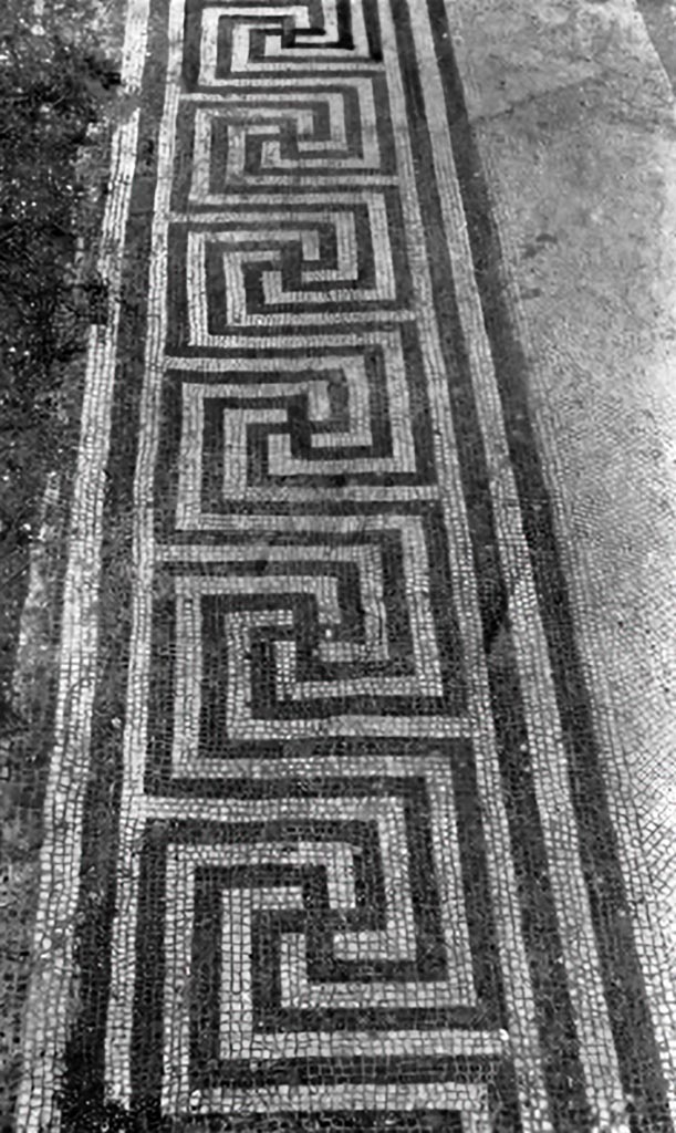 V.1.7 Pompeii. c.1930. Threshold of room 18.
According to Blake, on each end was a mosaic square set into the meander. 
See Blake, M., (1930). The pavements of the Roman Buildings of the Republic and Early Empire. Rome, MAAR, 8, (p.84 & Pl. 21, tav.5).