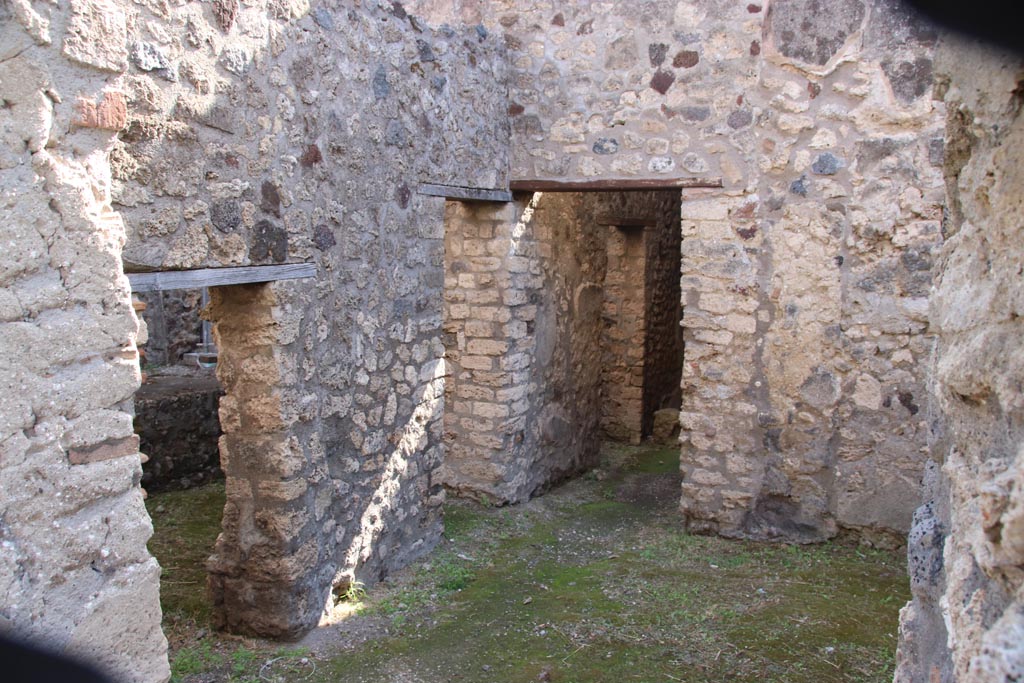 V.1.11 Pompeii. October 2023. 
Looking south-east from entrance doorway towards latrine with low doorway, then kitchen doorway, followed by corridor leading into V.1.18.
Photo courtesy of Klaus Heese.