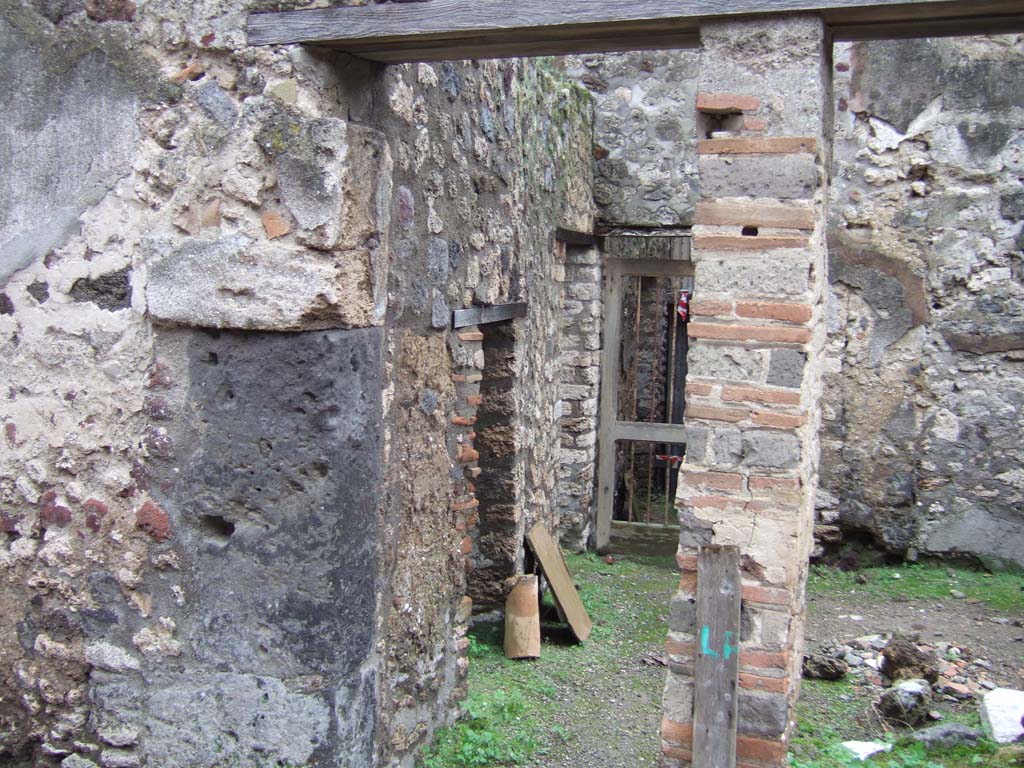 V.1.11 Pompeii. December 2005. Entrance doorway, looking south.
In the east wall, (on the left), are two doorways – 
the nearest into a latrine, the second into the kitchen with a hearth against the east wall and the lararium niche above it.