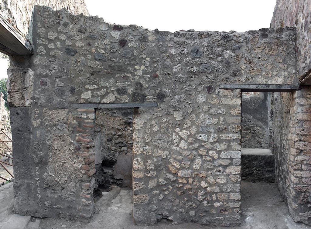 V.1.11 Pompeii. c.2005-7? 
Room “w”, east wall with doorway to latrine (“z”), on left, and to kitchen (“t”) on right.
Photo by Hans Thorwid.
Photo courtesy of The Swedish Pompeii Project.