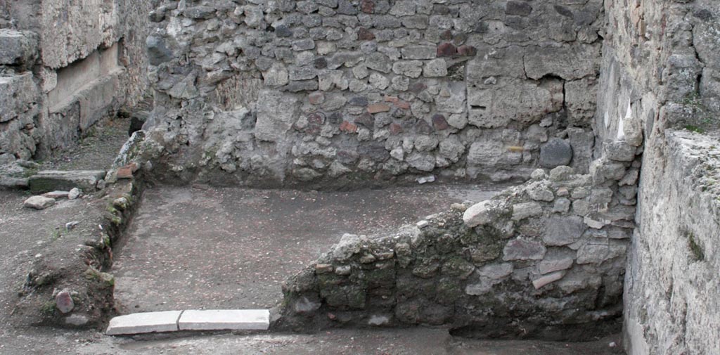 V.1.13 Pompeii. 2005. West wall of rear room “d”, before reconstruction, with doorway into room “e”. Photo by Hans Thorwid. 
“Room “e” is the only room in the caupona with high quality decorations. A cocciopesto floor with a circular mosaic pattern in the centre, has undecorated areas for clinae along the N and W walls. A marble threshold with two pivot holes is preserved in the doorway. A highly placed window, with recently restored window frame, opens to Vicolo delle Nozze d’Argento.”
Photo and words courtesy of the Swedish Pompeii Project.