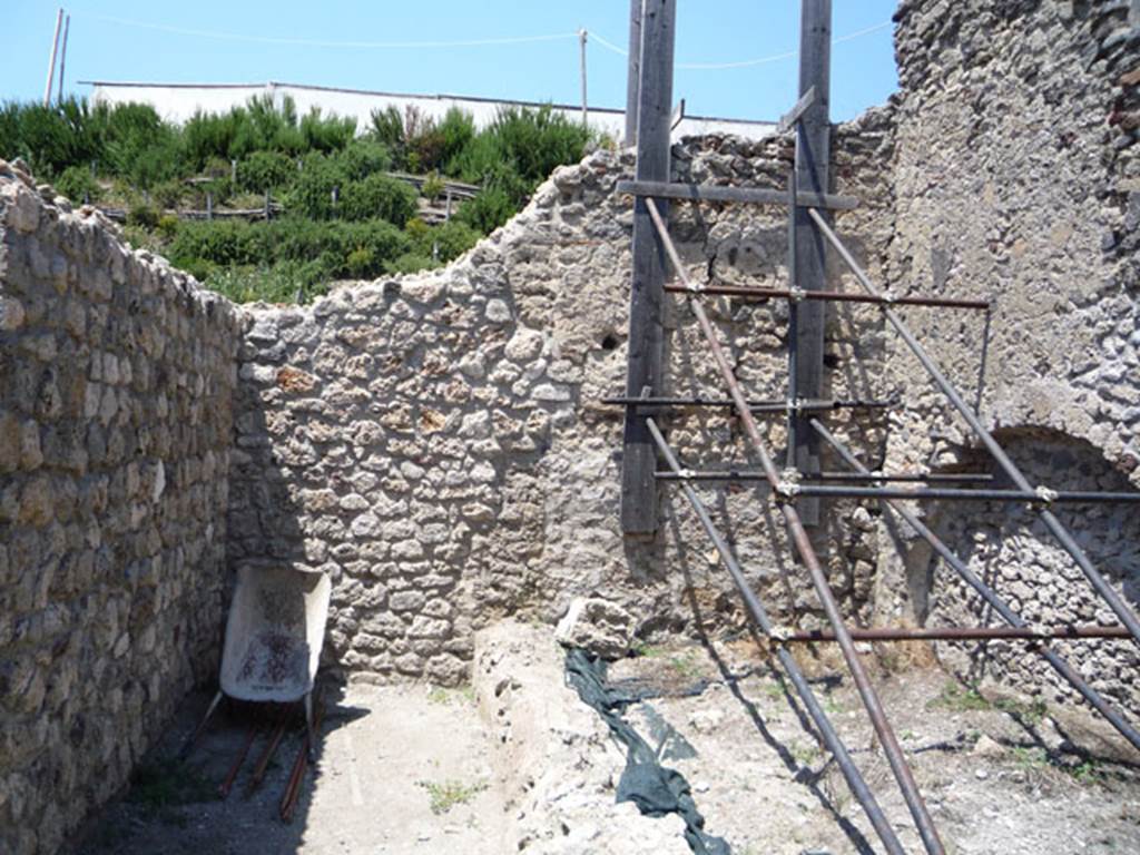 V.1.15 Pompeii. July 2008. 
Looking towards north wall of small garden area, and site of small oven (on left). Photo courtesy of Jared Benton.
According to Boman and Nilsson -
“Northern oven
The northern oven was completely destroyed by a bomb hit in 1943. 
Nothing more than some crushed lava stones, brick, tiles and dark brown clay mortar were found scattered in the area of the N oven.”
See The Swedish Pompeii Project.