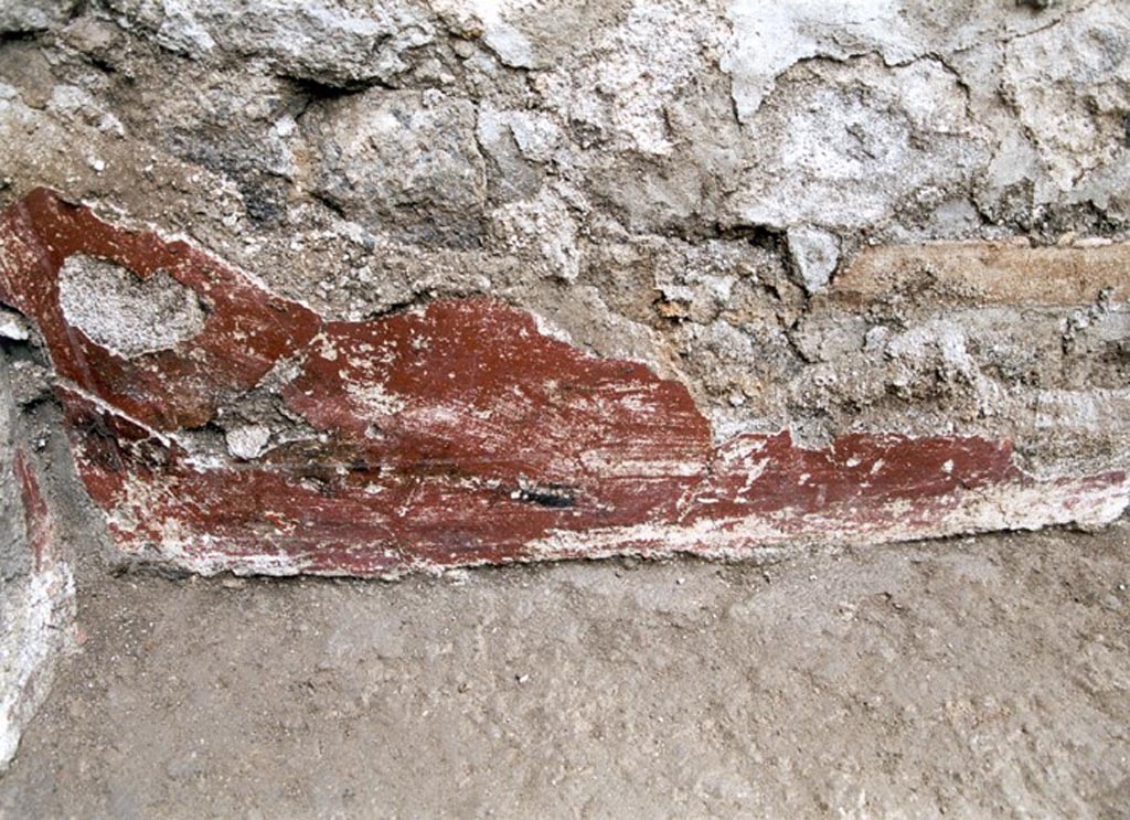 V.1.15 Pompeii. Not dated. 
West wall in south-west corner, detail of remaining red-coated plaster decoration. 
Photo by Henrik Boman. 
Photo courtesy of the Swedish Pompeii Project.